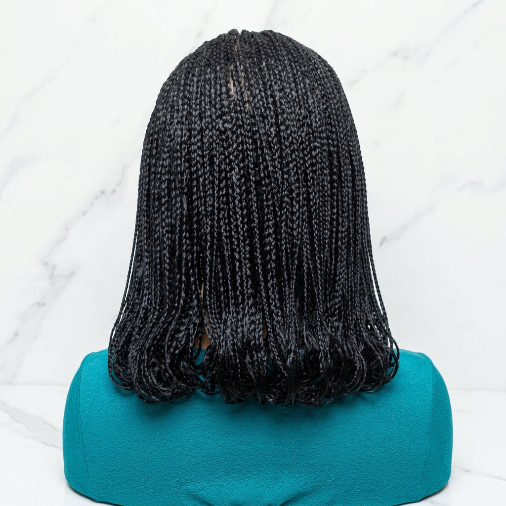 Black braided synthetic hair extensions styled in a low braid, 