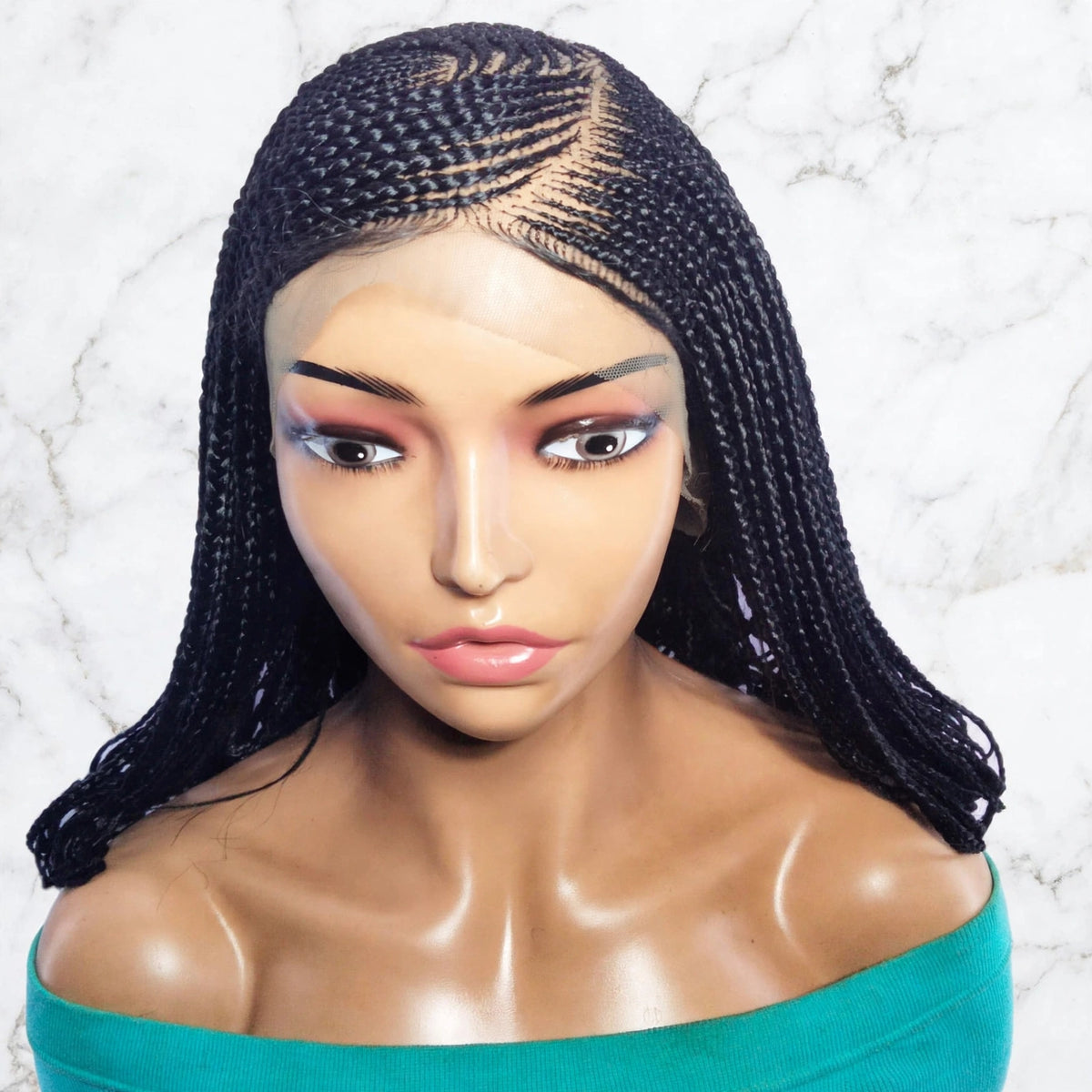 Black synthetic braided hair extensions styled on a female mannequin bust against a white marble background.